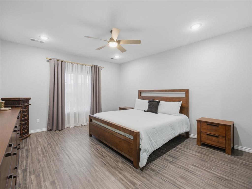 117 Ranchview Court Bowie, TX 76230 - Photo 14 of 40 a bedroom with a bed and a chandelier