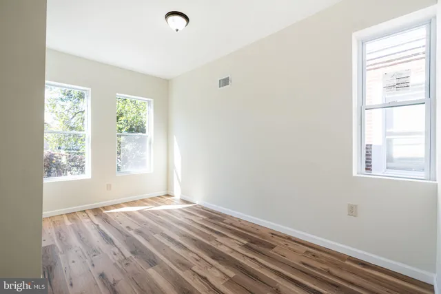 a view of a room with wooden floor and windows