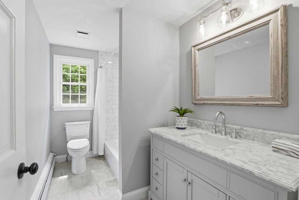 94 Johnson Road Winchester, MA 01890 - Photo 26 of 40 a bathroom with a granite countertop sink a toilet and a mirror