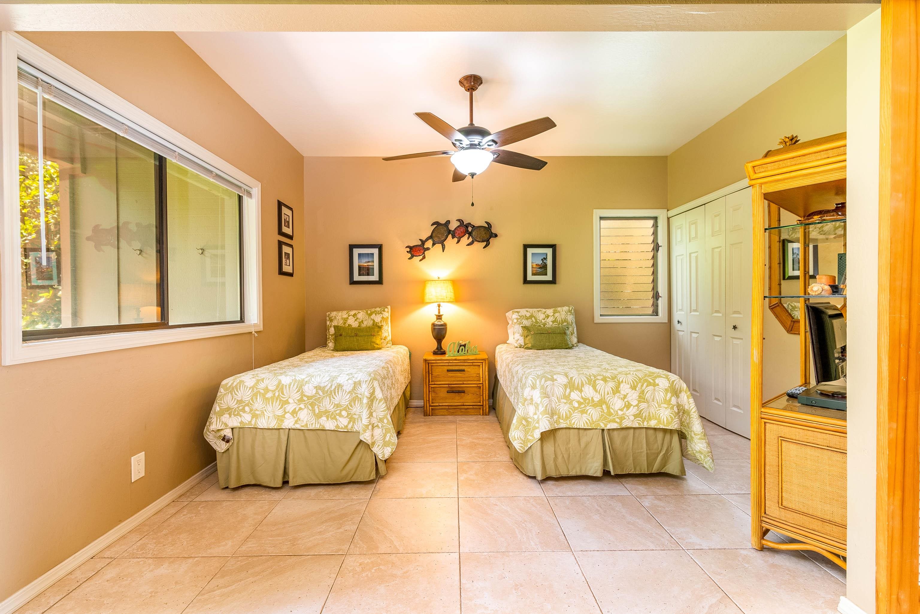 4440 Lower Honoapiilani Road, Unit 154 Lahaina, HI 96761 - Photo 14 of 32 a spacious bedroom with a bed and a chandelier