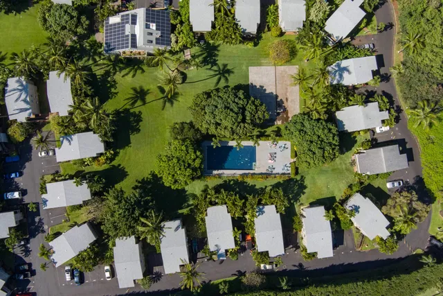 an aerial view of a house with a yard and large trees