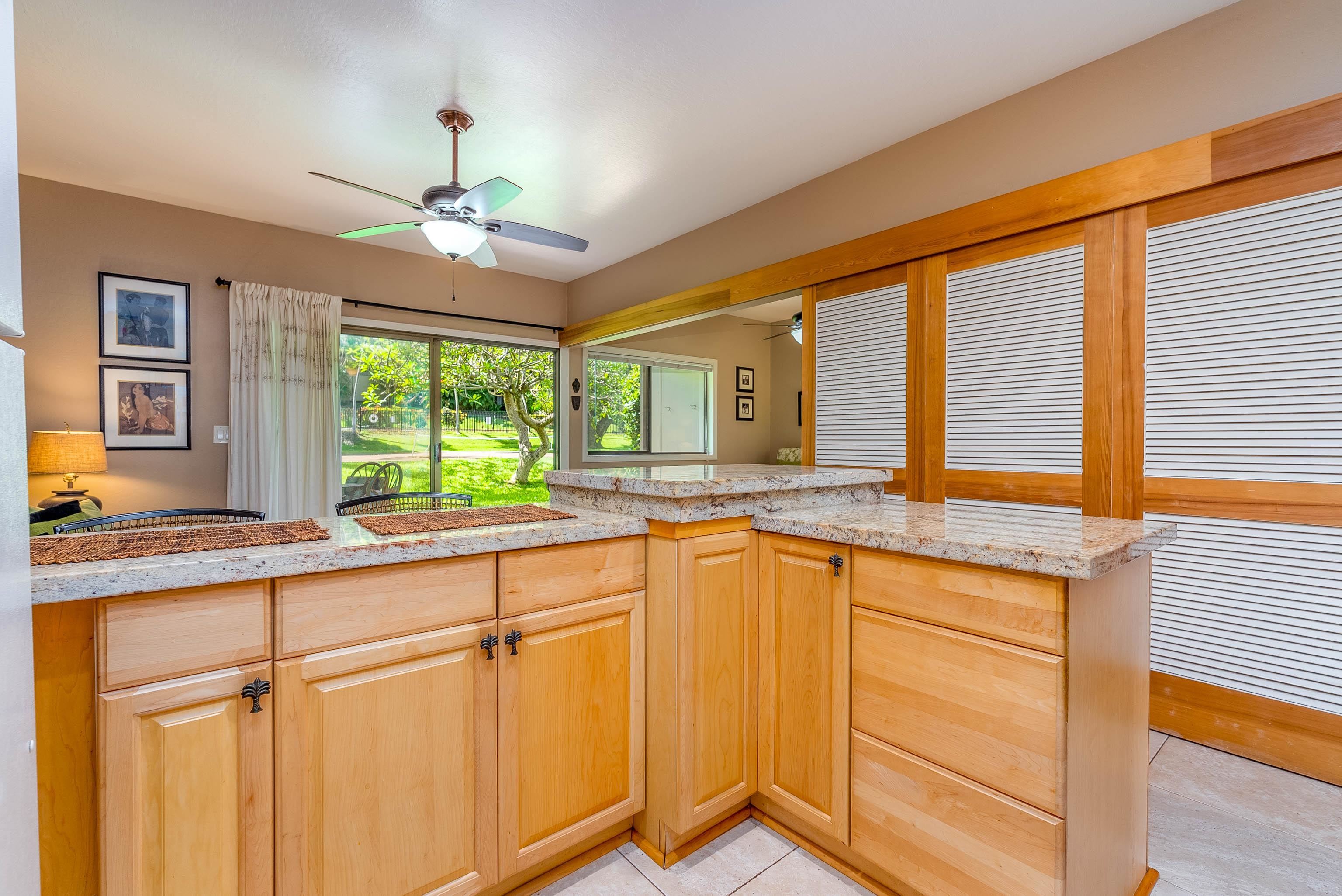 4440 Lower Honoapiilani Road, Unit 154 Lahaina, HI 96761 - Photo 5 of 32 a view of a kitchen counter top space with granite countertop stainless steel appliances sink and wooden floor