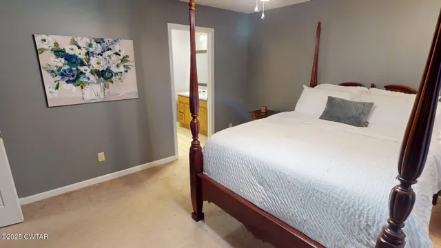 a bedroom with a bed and a painting on the wall