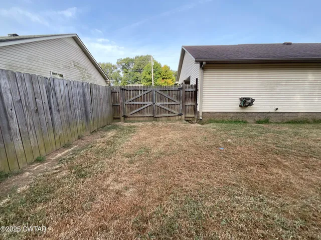 a backyard of a house with table and chairs