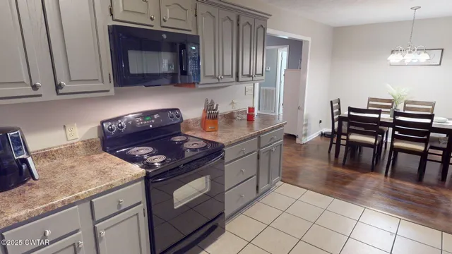 a kitchen with granite countertop a stove top oven a sink a dining table and chairs