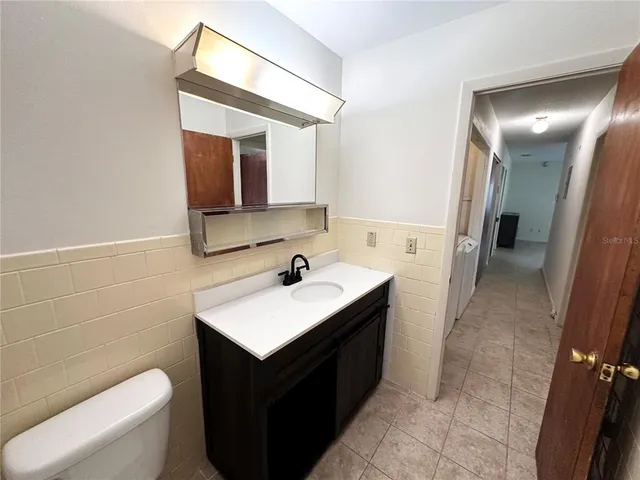 a bathroom with a sink toilet vanity and mirror