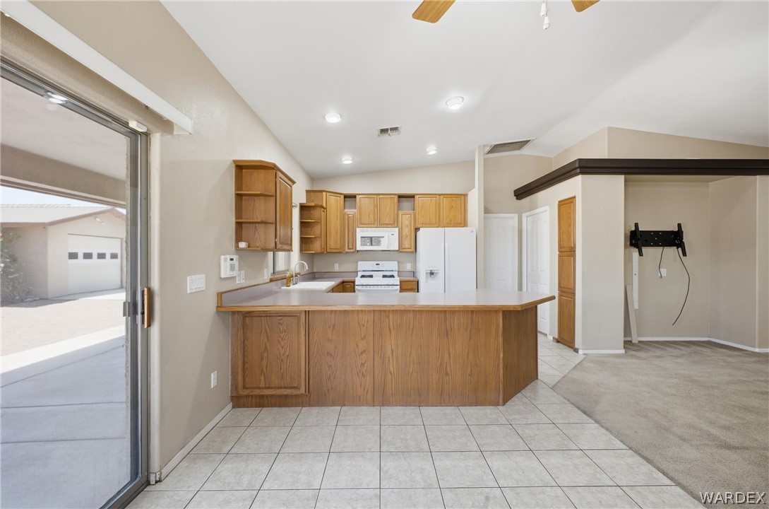 3918 North Eagle Rock Road Kingman, AZ 86409 - Photo 11 of 44 a large kitchen with stainless steel appliances kitchen island granite countertop a refrigerator and a sink