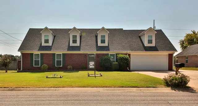 a view of a brick house with a yard