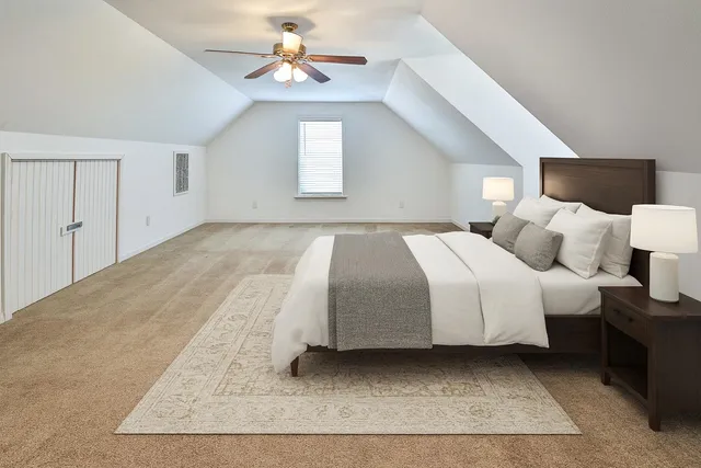 a bedroom with a bed lamp and a potted plant