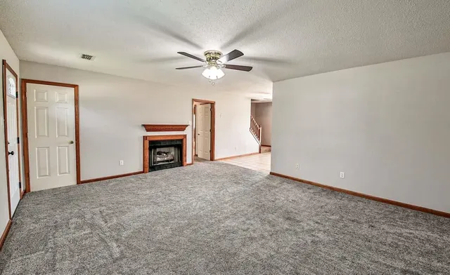 a view of a livingroom with a ceiling fan and a fireplace