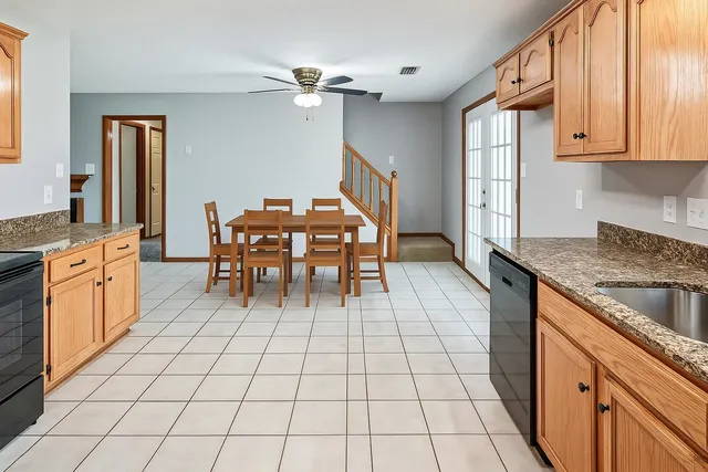 a kitchen with granite countertop a sink a stove cabinets and counter space