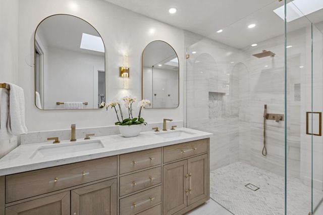 a bathroom with a double vanity sink mirror and shower