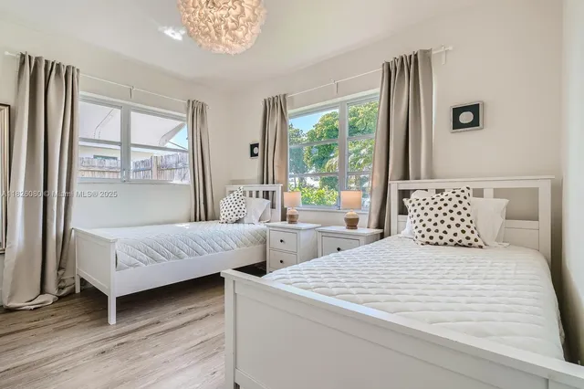 a bedroom with two beds and a large window