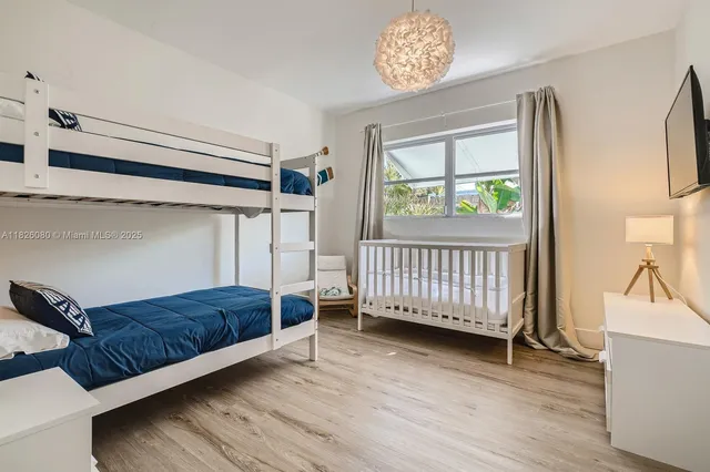 a living room with a baby crib furniture and a window