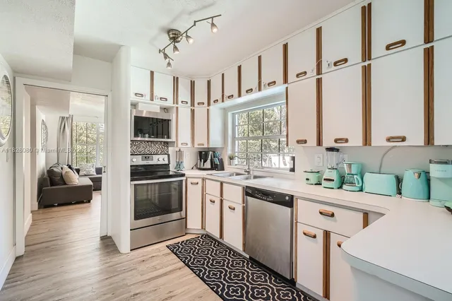 a kitchen with stainless steel appliances kitchen island granite countertop a sink and cabinets