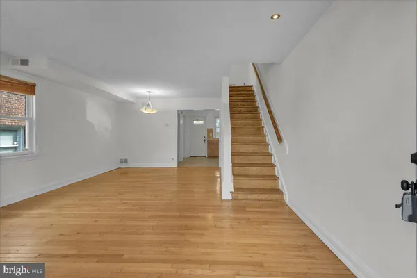 a view of a room with wooden floor and white walls