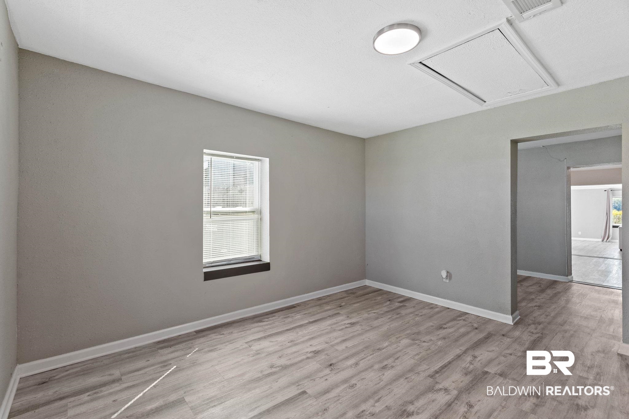 16796 Thompson Road Loxley, AL 36551 - Photo 15 of 93 Empty room with cooling unit, light wood-style floors, and healthy amount of natural light