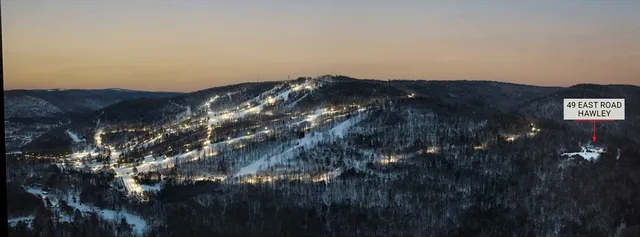 a view of an empty room with wooden floor and a floor to ceiling window