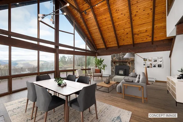 a view of an empty room with wooden floor and windows