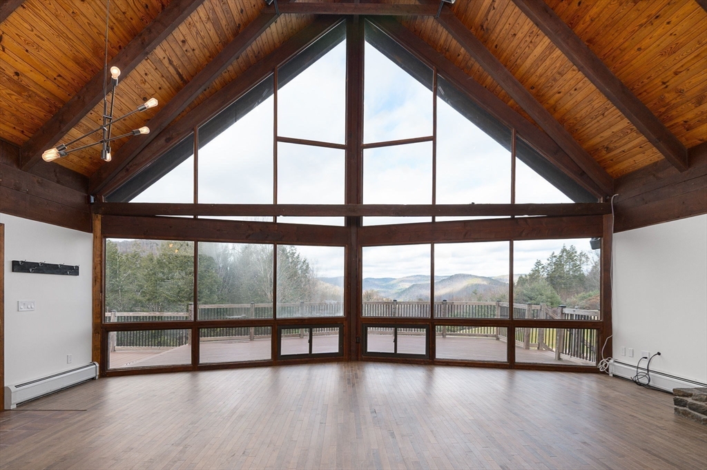 49 E Road Hawley, MA 01339 - Photo 7 of 42 a view of an empty room with wooden floor and a floor to ceiling window