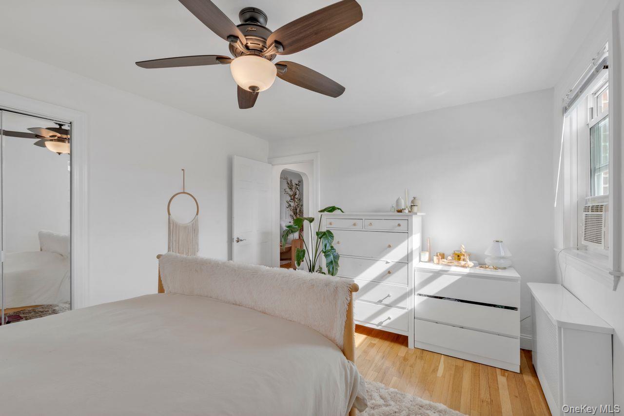 73-20 263rd Street, Unit G Queens, NY 11004 - Photo 15 of 24 a bedroom with a bed and a chandelier