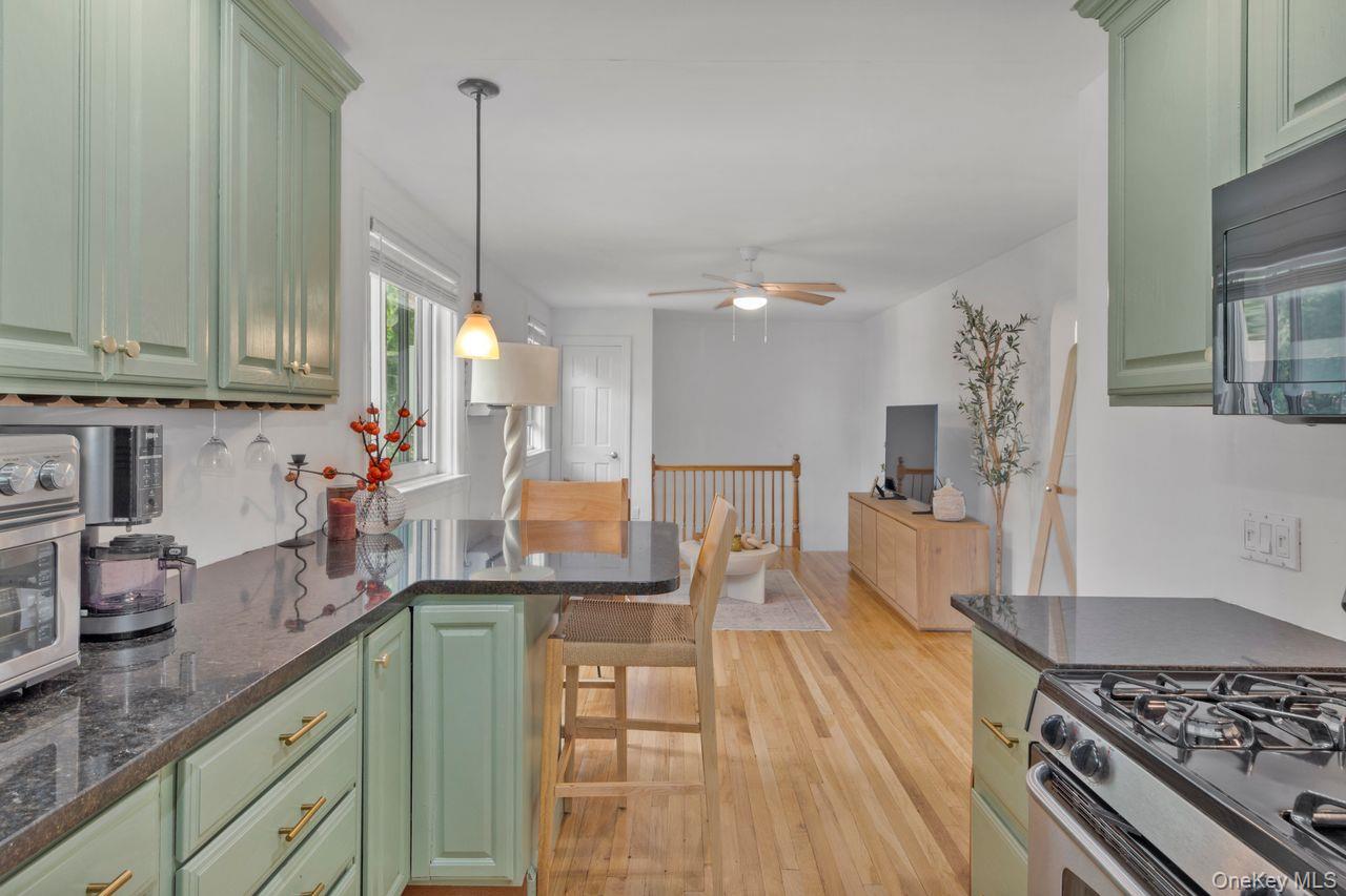 73-20 263rd Street, Unit G Queens, NY 11004 - Photo 7 of 24 a kitchen with kitchen island granite countertop a sink a counter space and stainless steel appliances