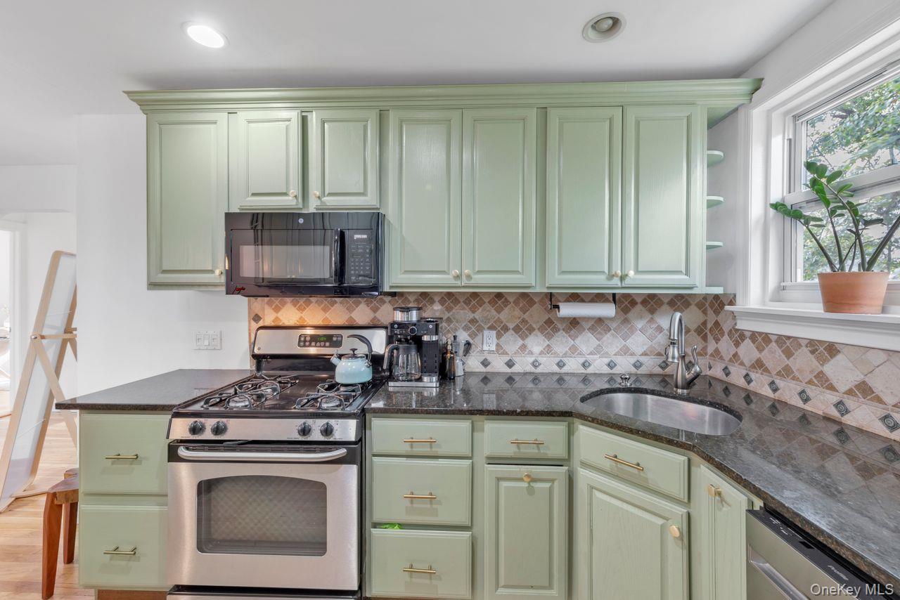 73-20 263rd Street, Unit G Queens, NY 11004 - Photo 10 of 24 a kitchen with granite countertop a sink stove and cabinets