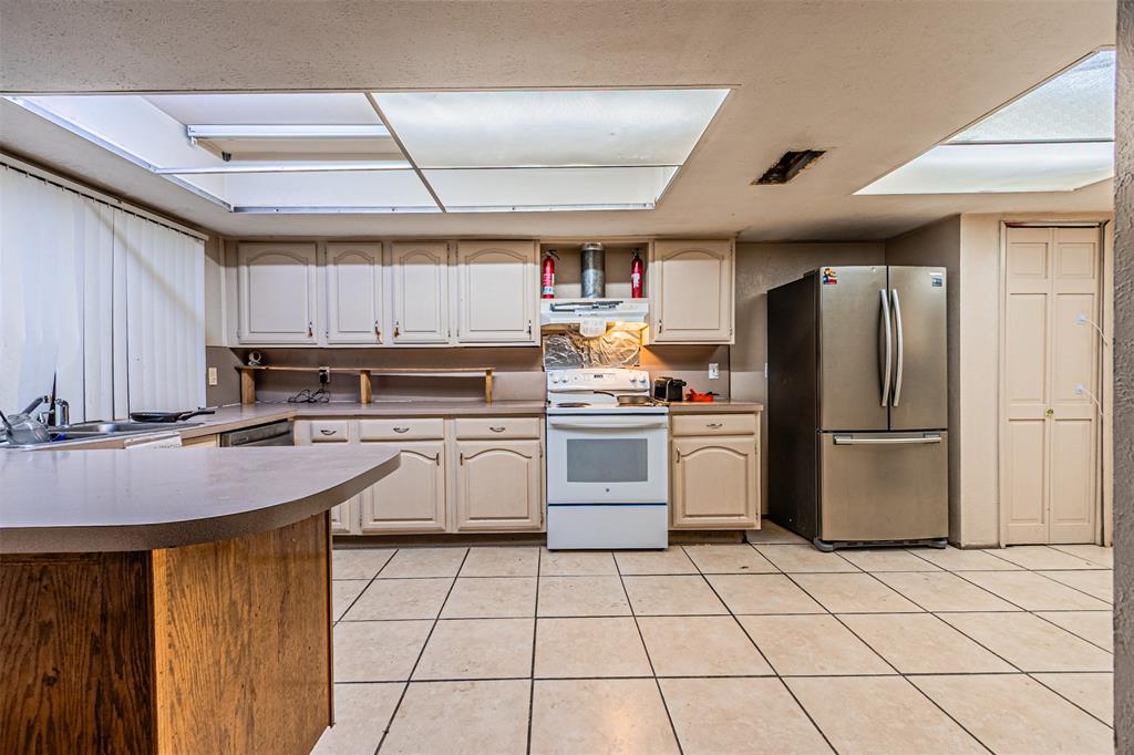 10315 Red Elm Road Dallas, TX 75243 - Photo 11 of 34 a kitchen with stainless steel appliances granite countertop a sink stove refrigerator and cabinets