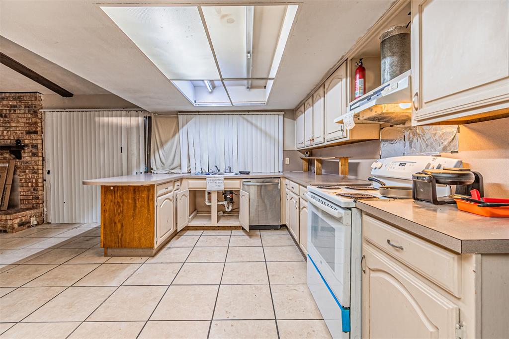 10315 Red Elm Road Dallas, TX 75243 - Photo 13 of 34 a kitchen with a sink a stove and cabinets