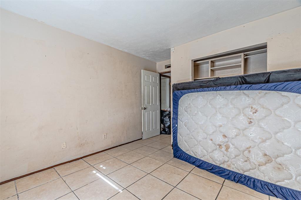 10315 Red Elm Road Dallas, TX 75243 - Photo 19 of 34 a bedroom with a bed and a cabinets