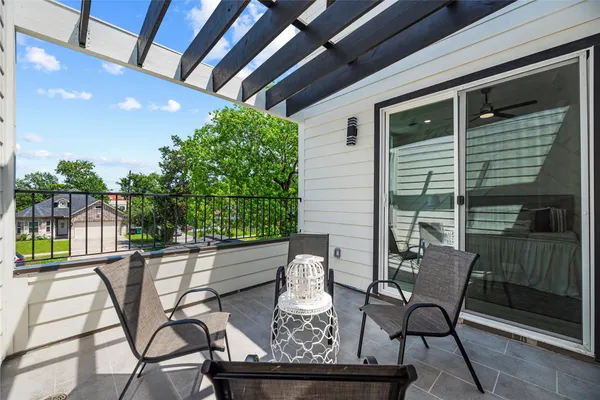 a roof deck with table and chairs and potted plants