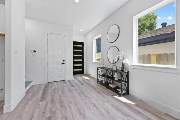 a view of a room with wooden floor fan and windows