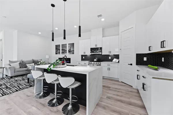 a kitchen with stainless steel appliances kitchen island granite countertop a sink and a refrigerator