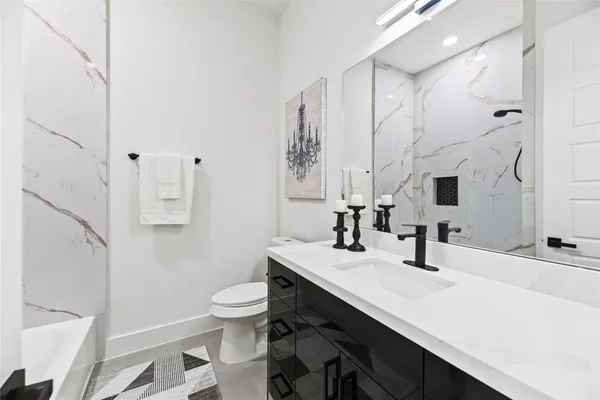 a bathroom with a sink a toilet a mirror and shower