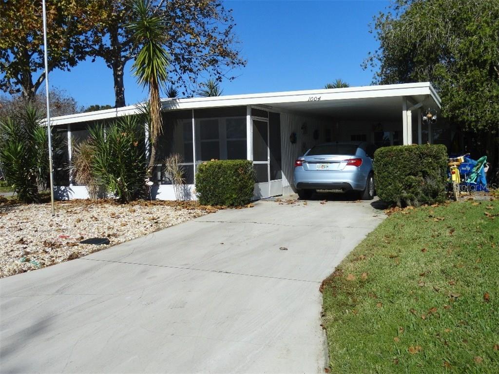 a view of house with backyard and outdoor seating