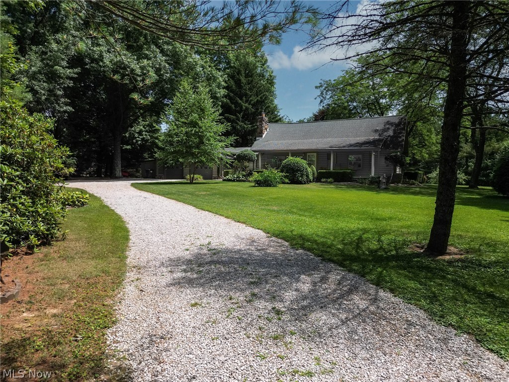 View of front facade from private driveway with a front lawn