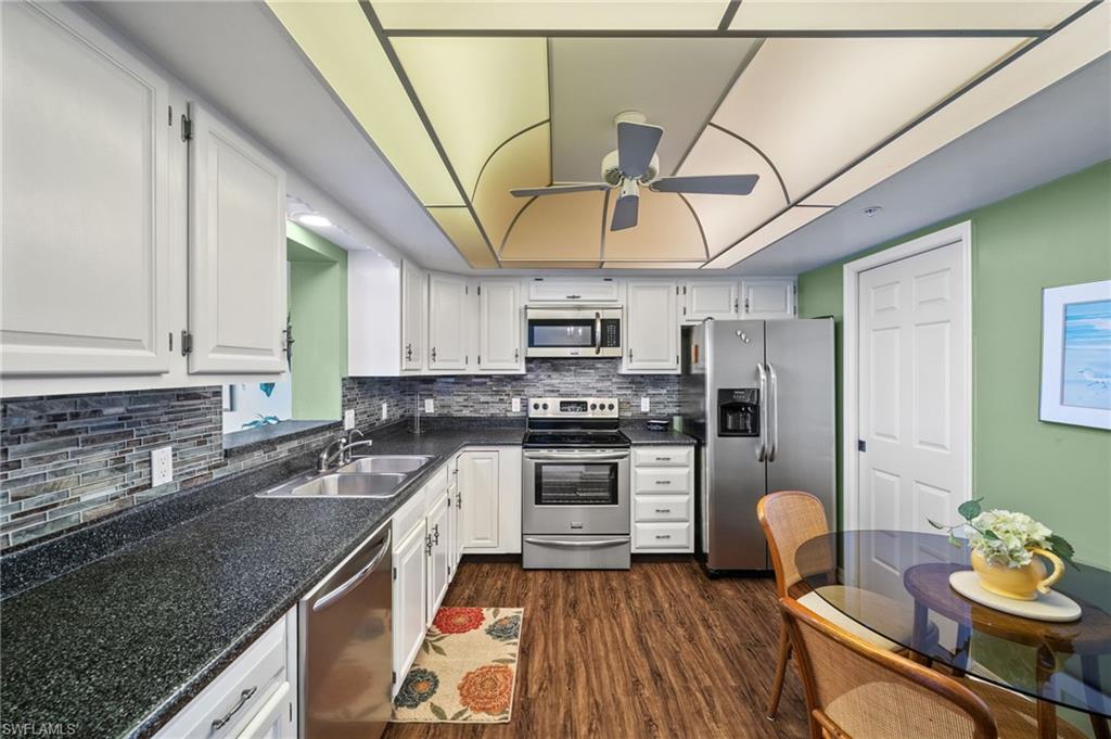 1900 Virginia Avenue, Unit 902 Fort Myers, FL 33901 - Photo 14 of 41 a kitchen with stainless steel appliances granite countertop a sink dishwasher stove and refrigerator with wooden floor