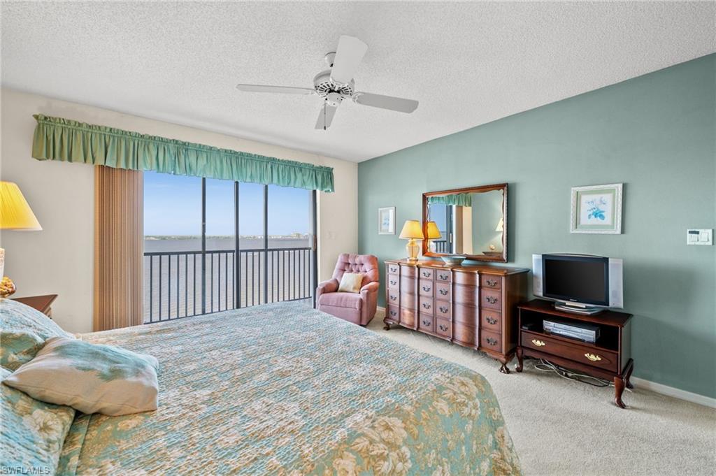 1900 Virginia Avenue, Unit 902 Fort Myers, FL 33901 - Photo 18 of 41 a bedroom with a bed and a chandelier