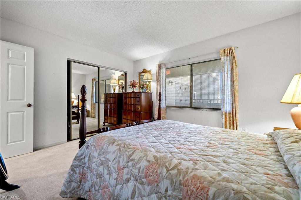 1900 Virginia Avenue, Unit 902 Fort Myers, FL 33901 - Photo 24 of 41 a bed room with a bed and a large mirror