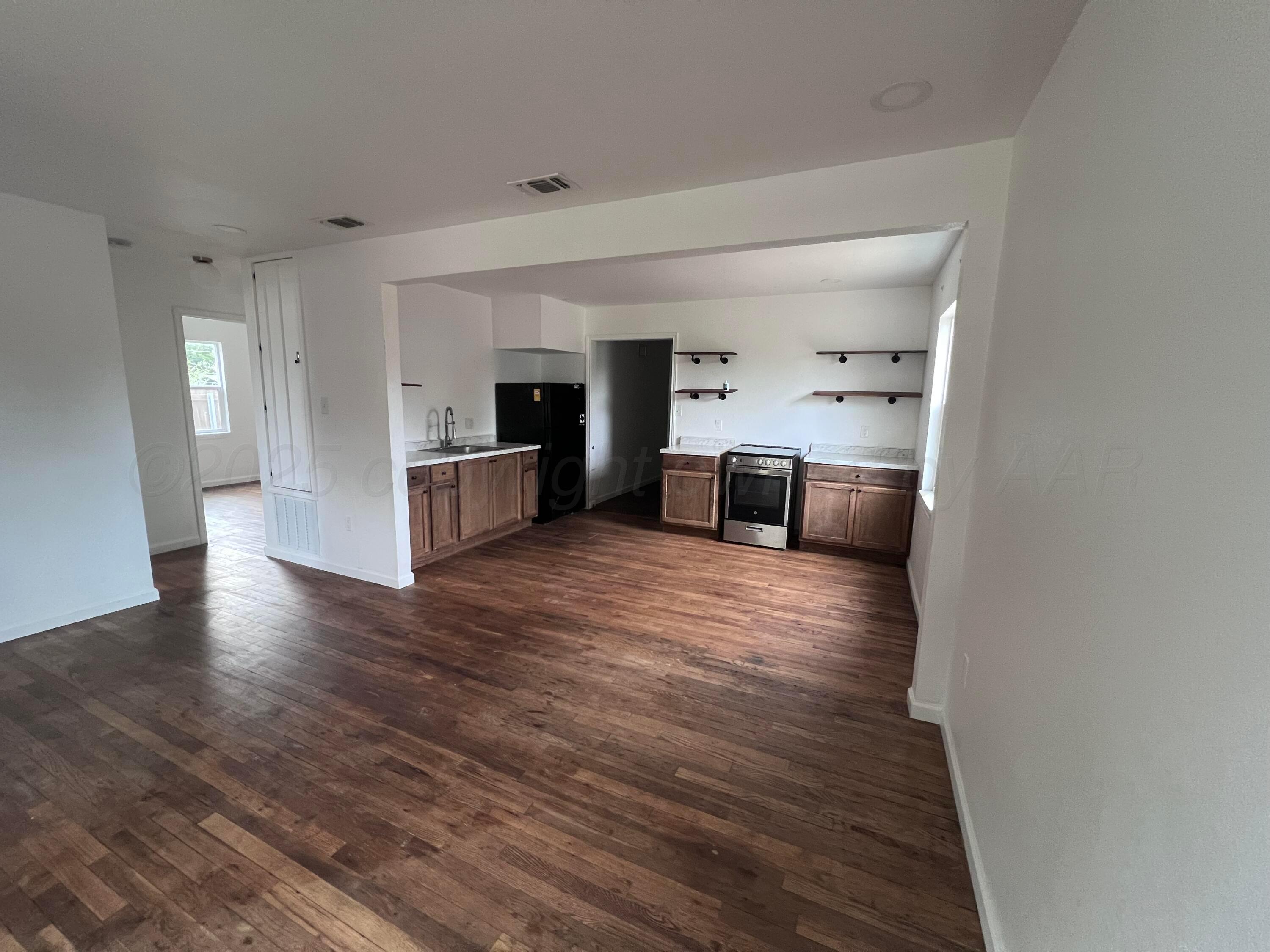 a view of a kitchen with a sink and a refrigerator