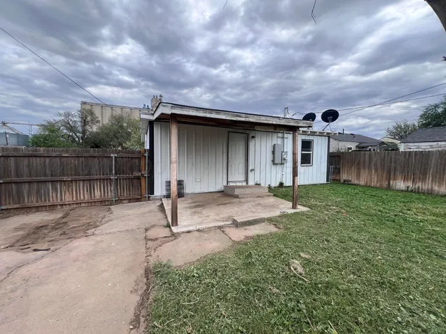 a backyard of a house with table and chairs