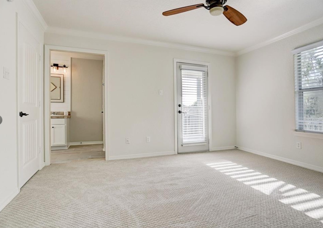 277 Capetown Conroe, TX 77356 - Photo 6 of 10 Spacious primary suite featuring plush carpeting, abundant natural light, and private access to the outdoors. The en-suite bathroom adds convenience and comfort, creating the perfect retreat at the end of the day.