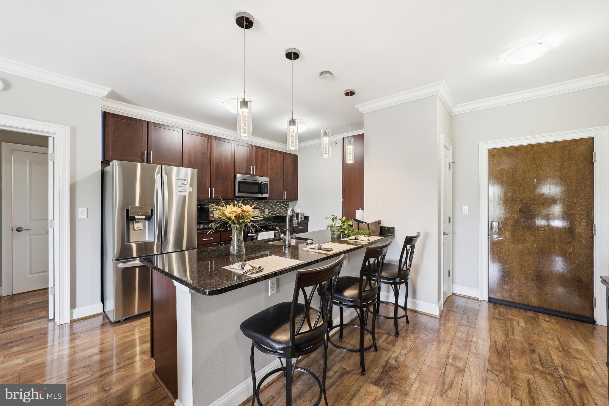 6301 Edsall Road, Unit 519 Alexandria, VA 22312 - Photo 1 of 33 a kitchen with stainless steel appliances a dining table chairs refrigerator and microwave