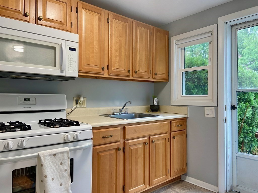 113 Manor Court, Unit 113 Springfield, MA 01118 - Photo 2 of 19 a kitchen with stainless steel appliances granite countertop a stove a sink and a microwave