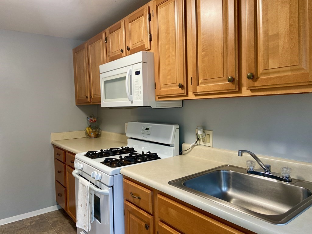 113 Manor Court, Unit 113 Springfield, MA 01118 - Photo 3 of 19 a kitchen with stainless steel appliances granite countertop a sink and a microwave