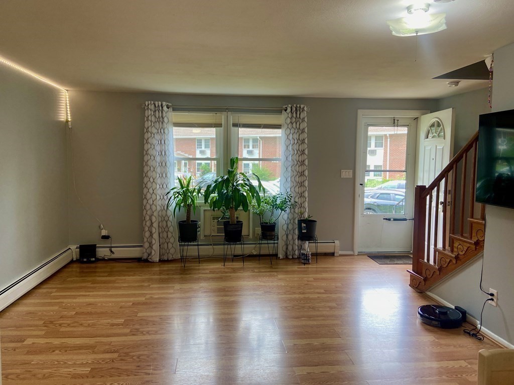 113 Manor Court, Unit 113 Springfield, MA 01118 - Photo 6 of 19 a view of an empty room with a window and wooden floor