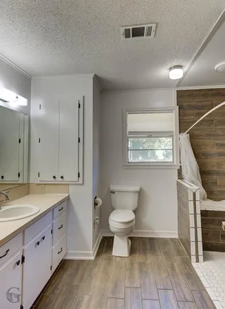 a spacious bathroom with a double vanity sink a mirror and a toilet