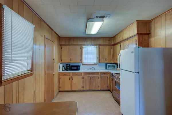 a kitchen with a refrigerator a sink and cabinets