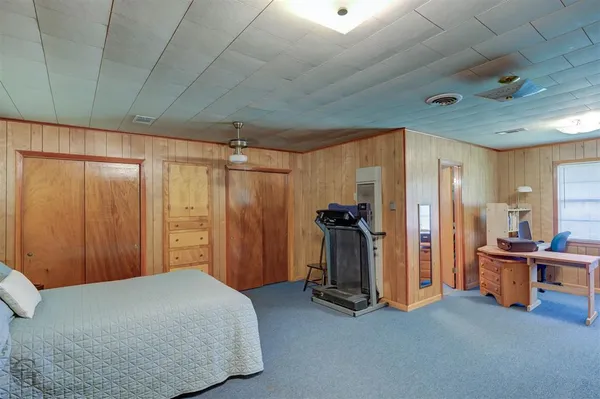 a bedroom with furniture and gym equipment