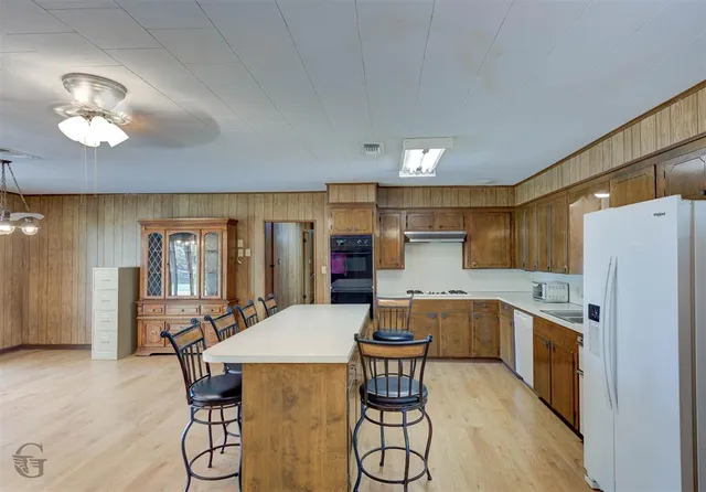 a kitchen with a table chairs refrigerator and cabinets